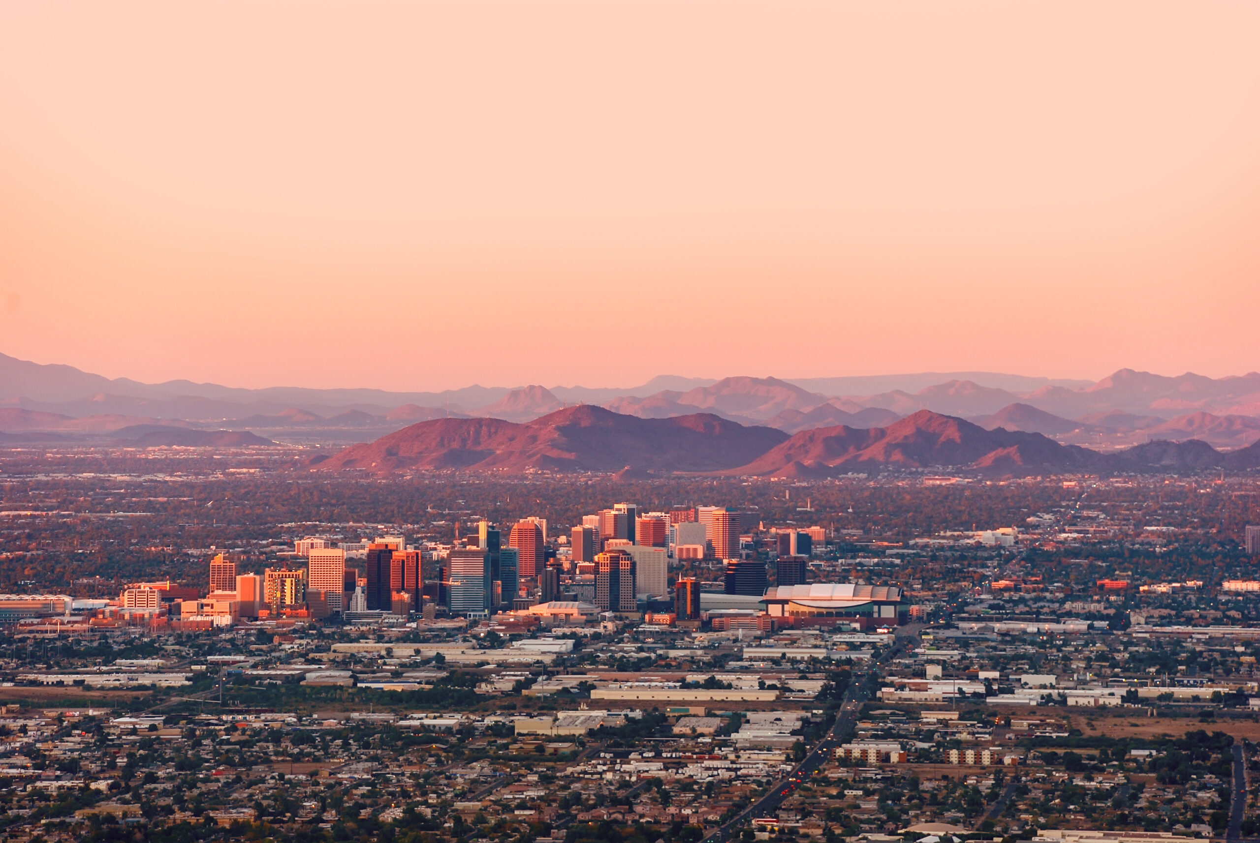A banner photo depicting a northward facing aerial photograph of Downtown Phoenix with mountains in the background